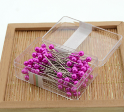 100 pearlescent needles in a colored plastic box. Paper positioning needle. Garment pin. Round pin.